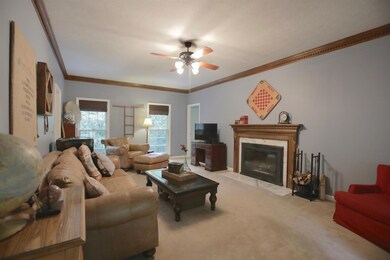 Wonderfully spacious living room with woodburning fireplace and custom crown molding.