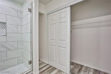 Bathroom with a shower stall and wood finished flo