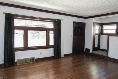 The living room boasts an original 1925 window with stunning woodwork!