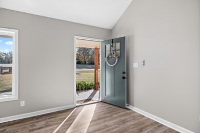 Foyer entrance featuring lofted ceiling and wood finished floors