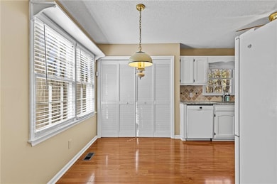 Kitchen featuring visible vents, white cabinets, w