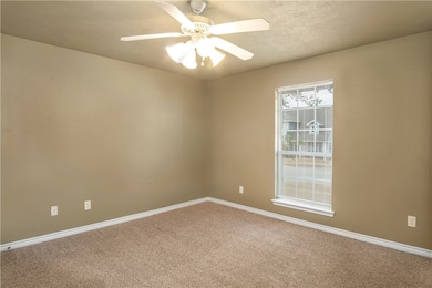 Carpeted spare room featuring baseboards and ceiling fan