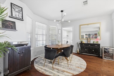 Dining area featuring a chandelier, dark wood-style flooring, washing machine and dryer, and wine cooler