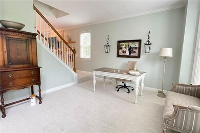 Carpeted home office featuring crown molding and b