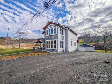 Gravel driveway continues around side of home and connects to Hemlock Rd providing additional access options to property.