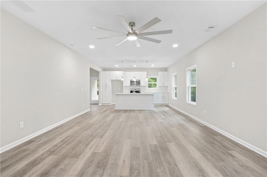 Unfurnished living room with ceiling fan, light wood finished floors, and recessed lighting