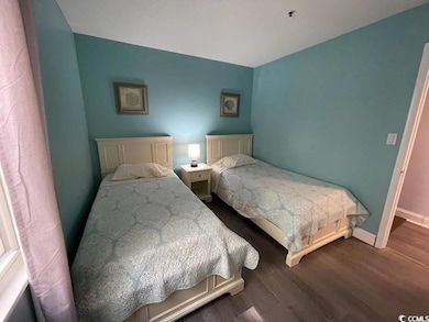 Bedroom featuring dark wood-type flooring and baseboards
