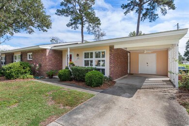 Ranch-style home with a front lawn and a carport