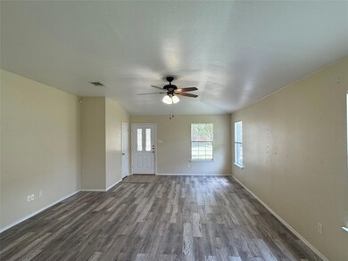 Unfurnished living room with dark wood-style floo