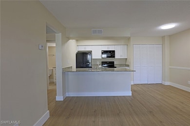 Kitchen featuring white cabinets, visible vents, b