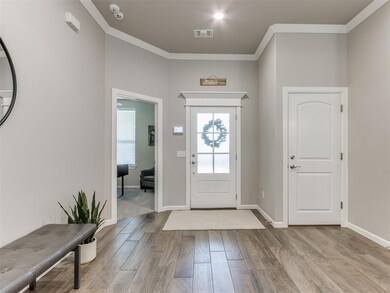 Foyer featuring ornamental molding and light wood-