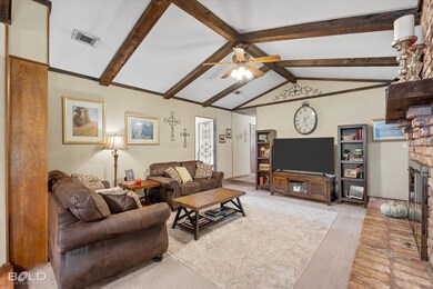 Carpeted living area with a fireplace and ceiling fan