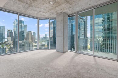 Unfurnished room with expansive windows, carpet, and a view of skyline