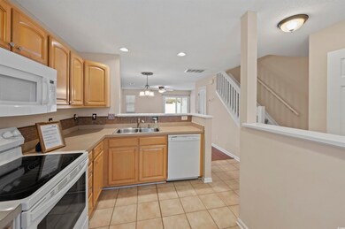 Kitchen with light countertops, visible vents, lig