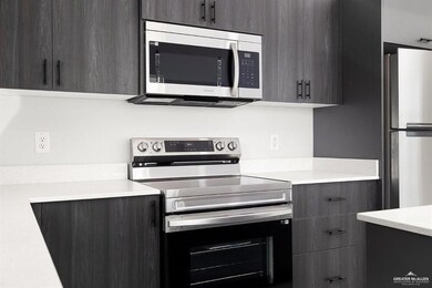 Kitchen with appliances with stainless steel finishes, modern cabinets, and light countertops