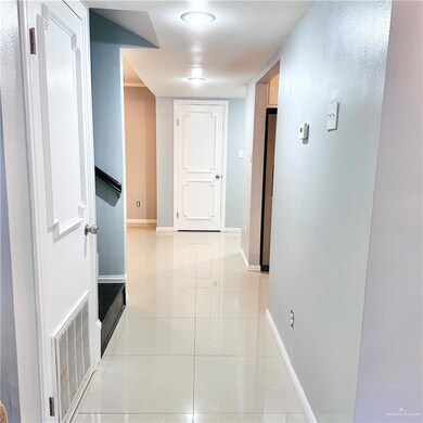 Hall featuring light tile patterned floors and baseboards