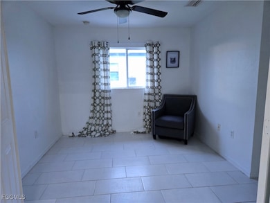 Unfurnished room with tile patterned floors and ceiling fan