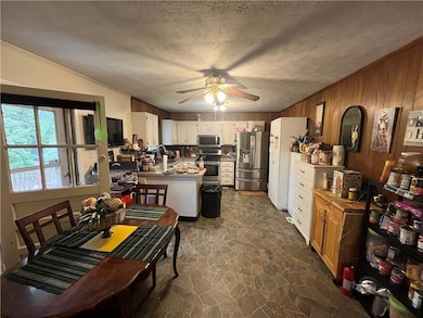 Kitchen featuring a ceiling fan, stone finish floo
