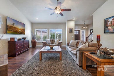 Living room featuring dark wood-type flooring, stairway, recessed lighting, and ceiling fan