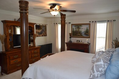 Large master bedroom with crown molding and ceiling fan