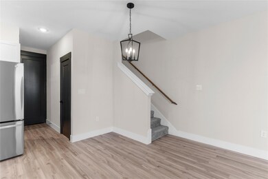 Unfurnished living room featuring a notable chandelier and light hardwood / wood-style flooring