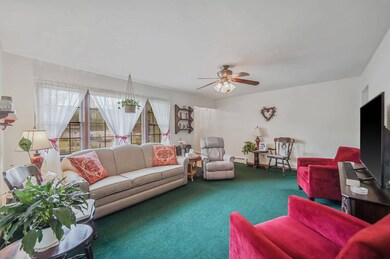 Carpeted living room with ceiling fan