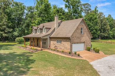 View of front of house with a garage, brick siding, concrete driveway, covered porch, and roof with shingles