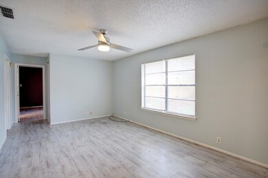 Unfurnished room featuring a textured ceiling, light wood-type flooring, and ceiling fan