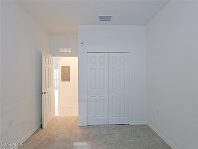 Unfurnished bedroom with electric panel and carpet