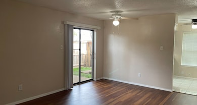 Spare room featuring dark wood-style flooring, a textured ceiling, and ceiling fan