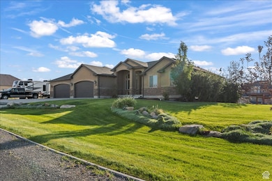 View of front of house with stucco siding, a front lawn, an attached garage, and driveway