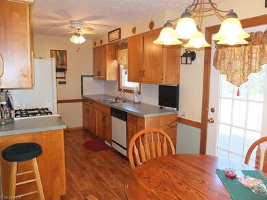 Fully applianced kitchen with tile backsplash.