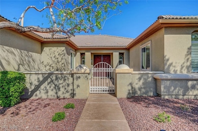 Property entrance with stucco siding, fence, a tile roof, and a gate