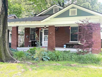 View of front of house with a porch, brick siding, and a shingled roof