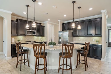 This kitchen features rich cabinetry, granite coun