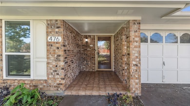 View of exterior entry with brick siding and covered porch