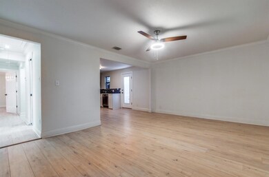 Spare room with ceiling fan, crown molding, and li