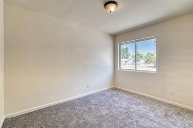 Spare room featuring carpet and baseboards