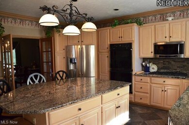 huge granite island, door off of kitchen goes outside to the deck