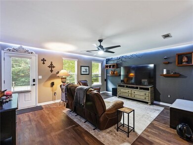 Living area featuring wood finished floors, ceiling fan, and baseboards