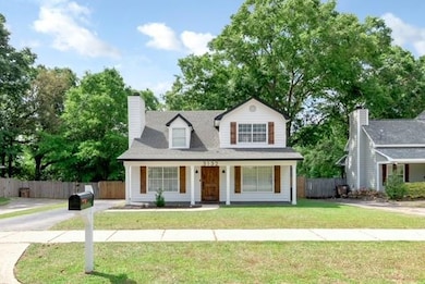 View of front facade with covered porch and a chimney