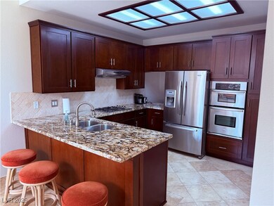 Kitchen featuring under cabinet range hood, a sink