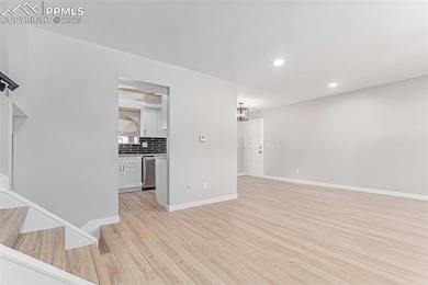 Unfurnished living room featuring light wood-type flooring, recessed lighting, and baseboards