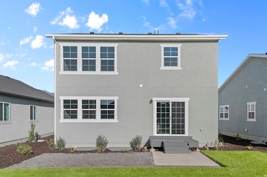 Rear view of property with stucco siding, entry steps, and a patio