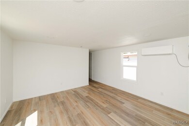 Unfurnished room with a textured ceiling, light wo