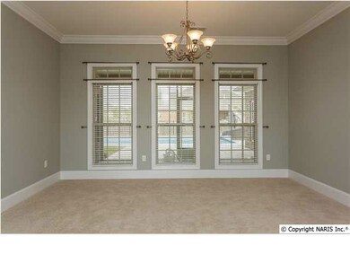 Carpeted parlor with tall windows overlooking back yard.