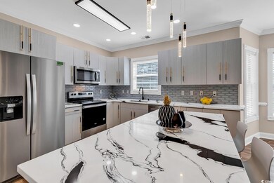 Kitchen featuring decorative light fixtures, appli