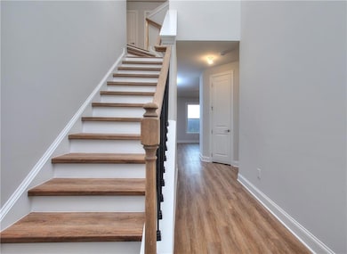 Staircase with baseboards and wood finished floors