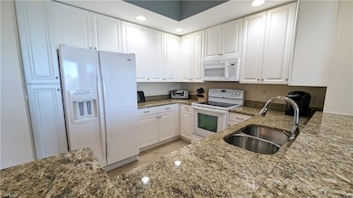 Kitchen featuring white cabinetry, granite counter