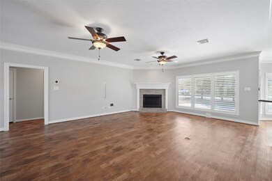 Spacious living area with corner fireplace, dual ceiling fans, plantation shutters, floor-plug for lamps etc, and upgraded wood-plank vinyl flooring here, and through out the entire home (no carpet!).